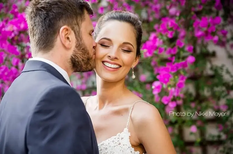 Groom kissing bride on cheek
